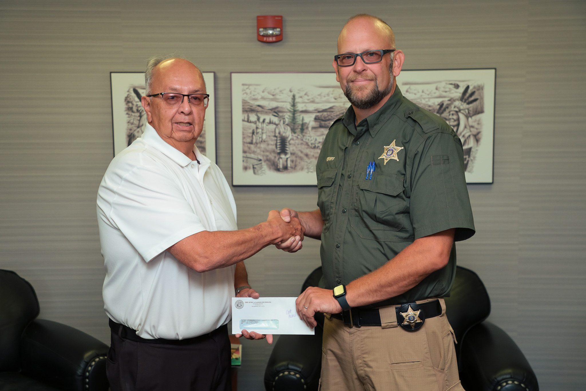 Seneca Nation President Rickey Armstrong Sr. (left), presents Cattaraugus County Sheriff with a $30,000 check to establish a new K-9 unit for the Sheriff's Department.