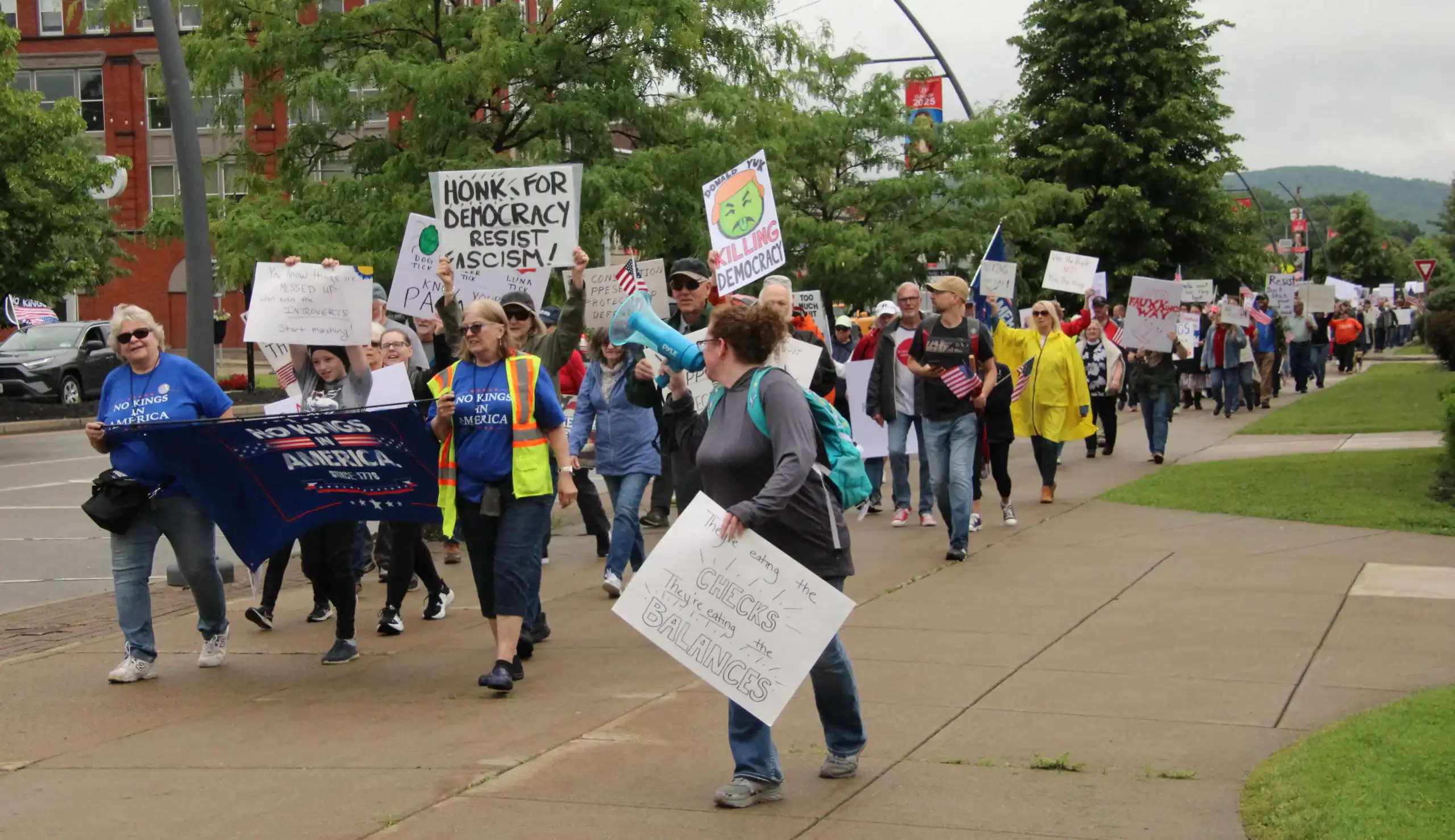 (Rick Miller/Olean Star) Liz Boyer (left) and Mary Brooks, both of Randolph, carried the No Kings in America banner during a march on North Union Street to Lincoln Park on Saturday. Organizers said more than 400 people participated.