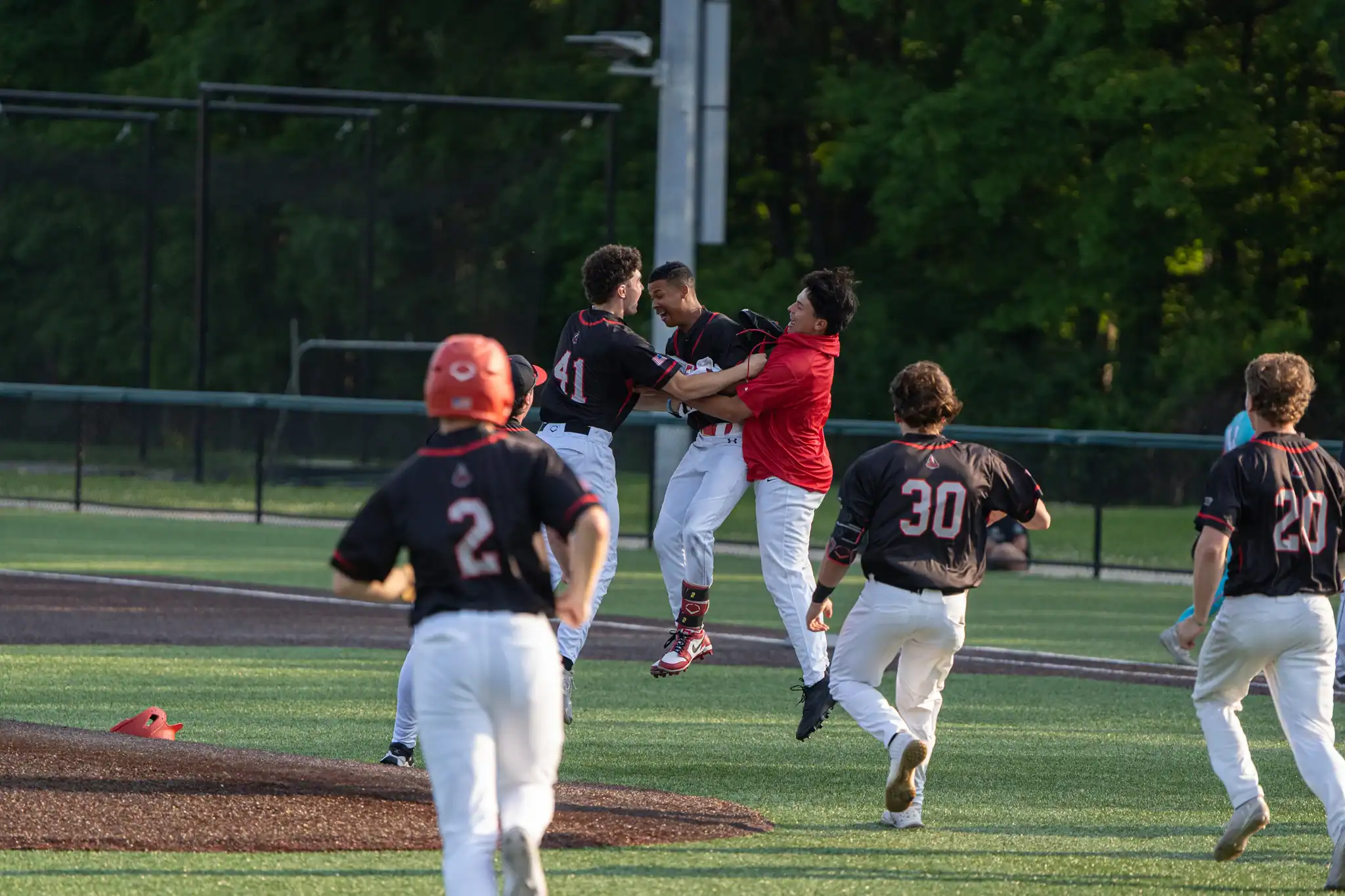 The Olean Oilers rush the field to celebrate with Josh Wilson who sealed the win in the first game of a double-header against the Syracuse Salt Cats with a walk-off RBI single. | Photo by Hunter O. Lyle