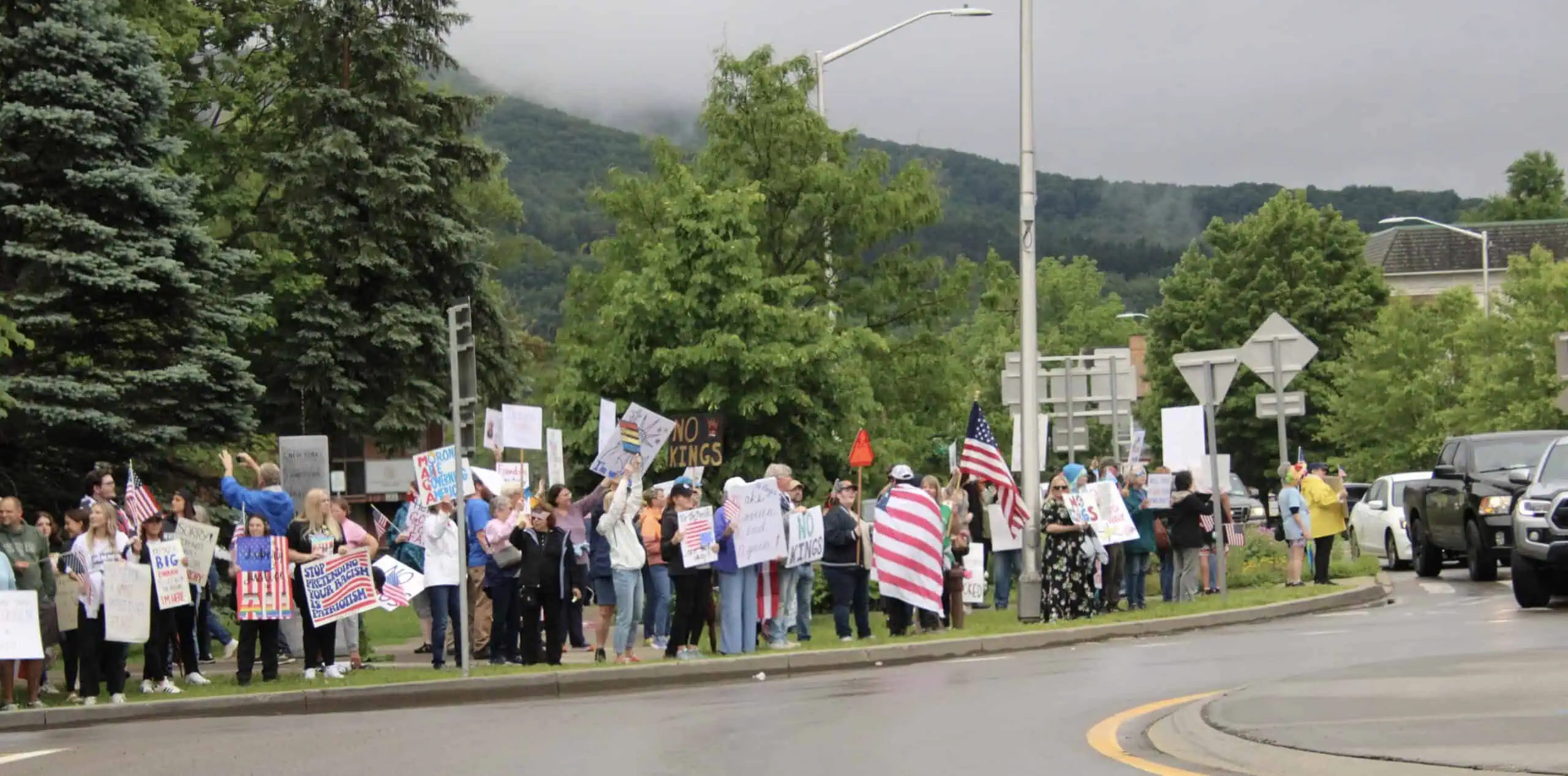 (Rick Miller/Olean Star) Protesters lined up along East State Street at Lincoln Park last month demonstrate against policies and cuts by President Trump.