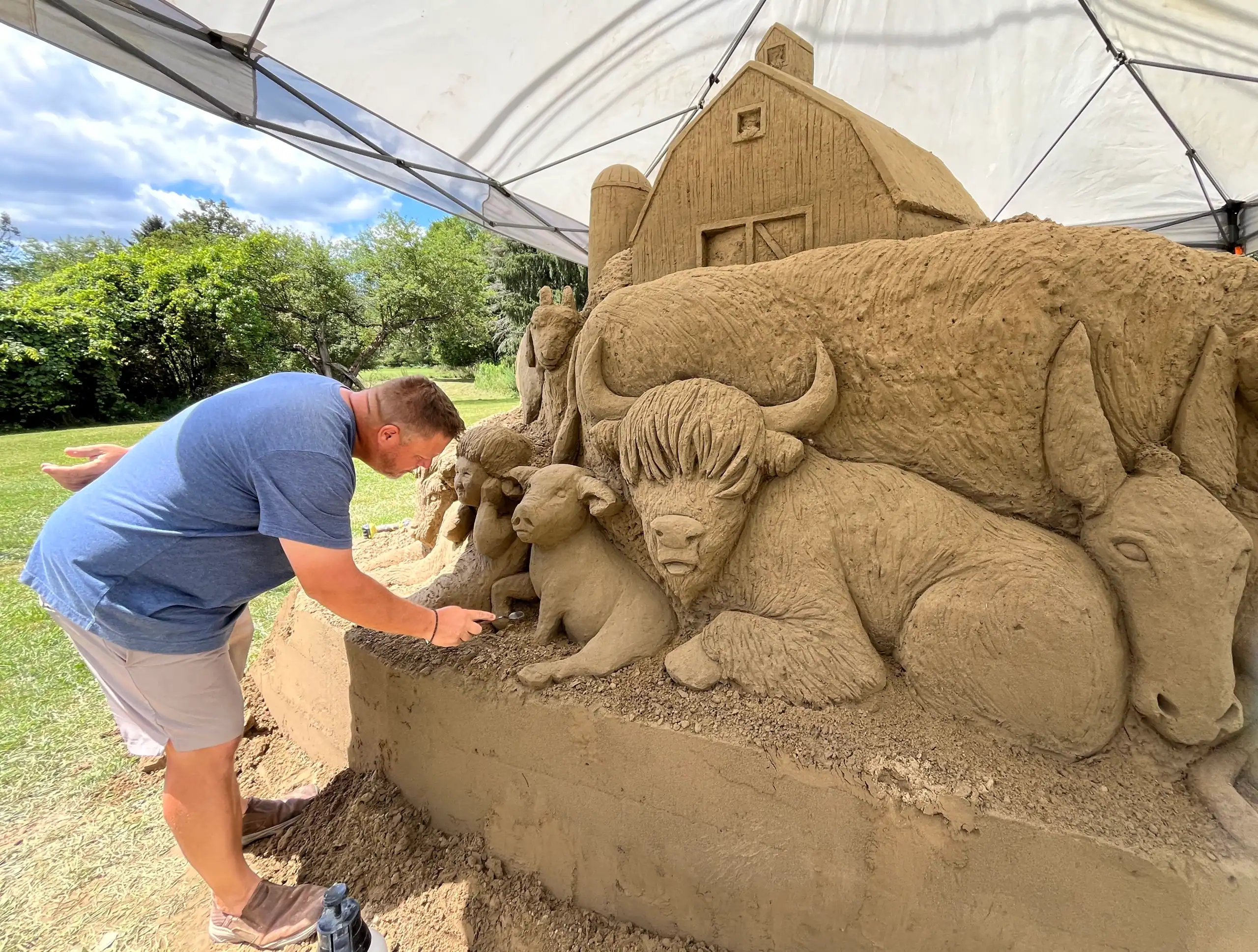 (Rick MIller/Olean Star) Eric Jones works on details of a 20,000-pound sand sculpture along Route 305 in front of the Clarksville Firemen’s Park Friday afternoon. Stop by and see the finished product and take part in the Community Celebration of Eric Jones Saturday beginning at 2 p.m. with a chicken barbecue.