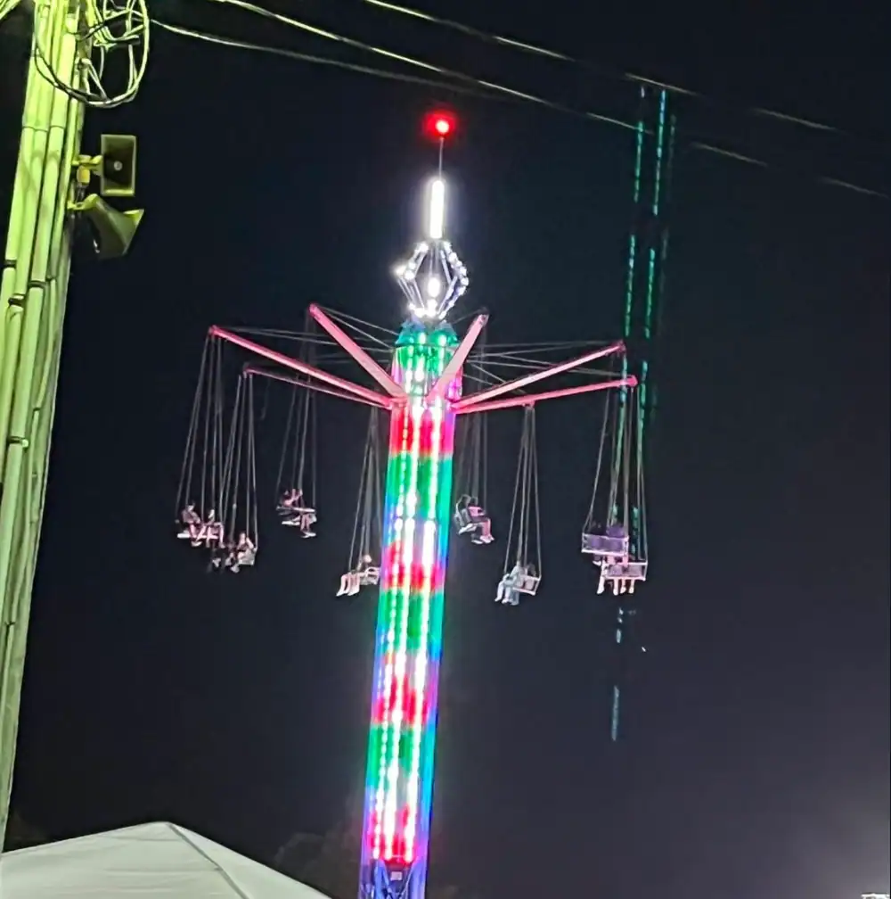 (Cattaraugus County Fair photo) Riders stranded on the swing ride at the Cattaraugus County Fair Saturday night await volunteer firefighters and ladder trucks from Little Valley and Ellicottville. There were no injuries.