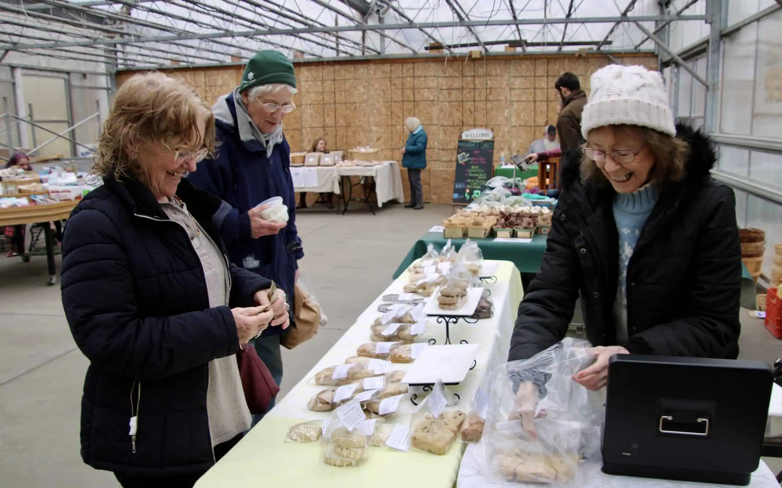 (Rick Miller/Olean Star) Coni Coletti (right) of Rolling Scones Baking Company, rings up a sale for Carla Keirstead of Olean (left) as Barbara Casey of Olean waits her turn at the checkout at the Olean Area Farmers Market Winter Market at Miller's Farm Market on Olean-Portville Road.