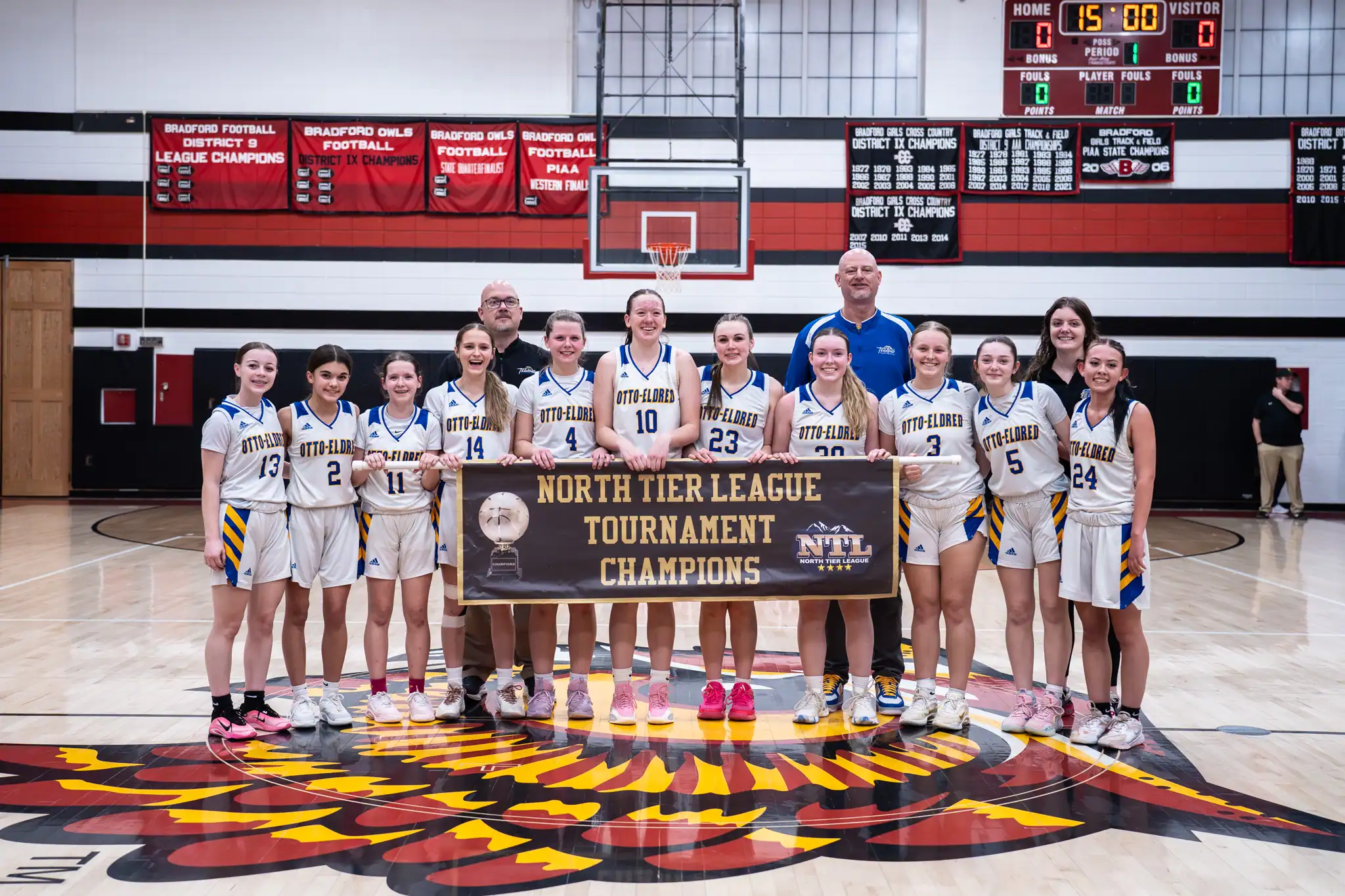 The Otto-Eldred girl's basketball team poses with their newly-acquired North Tier League Tournament banner after beating Port Allegany in the championship game. | Photo by Taylor Komidar