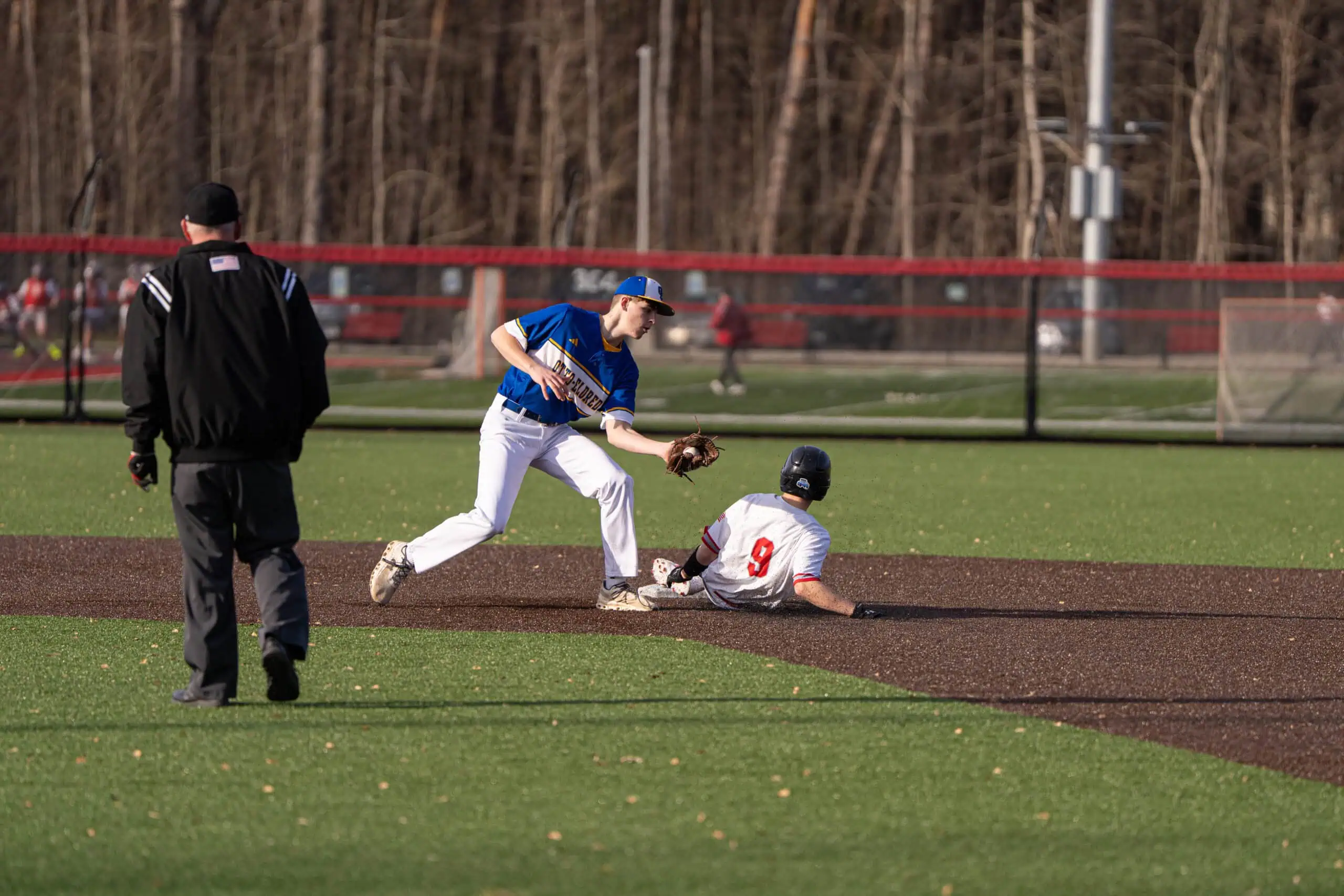 Salamanca's Nolan Seeley (9) narrowly avoids a tag out from Otto-Eldred's Jack Sherry (8) during the Warriors win over the Terrors on Tuesday. | Photo by Hunter O. Lyle